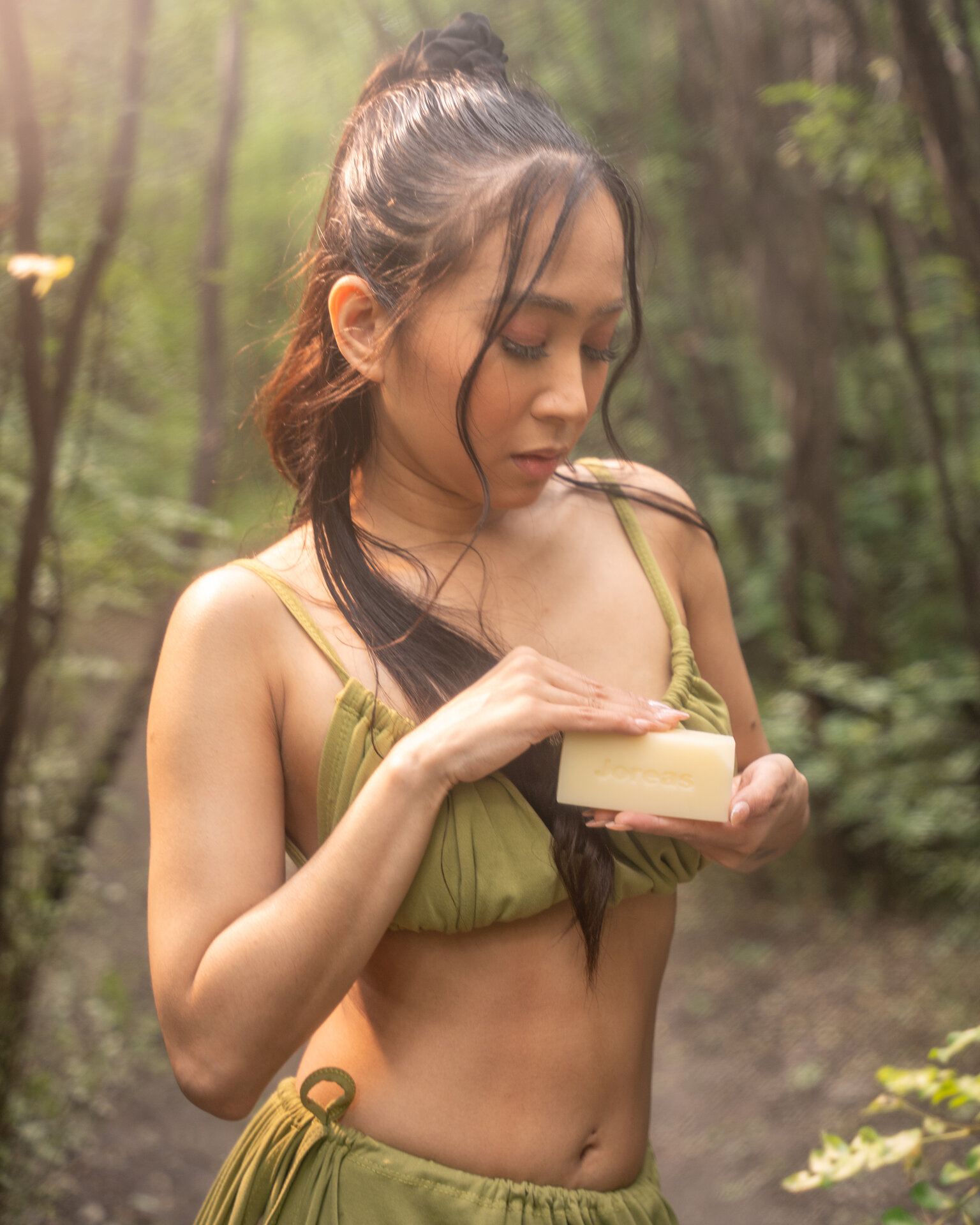 Creative portrait in a forest holding a bar of soap