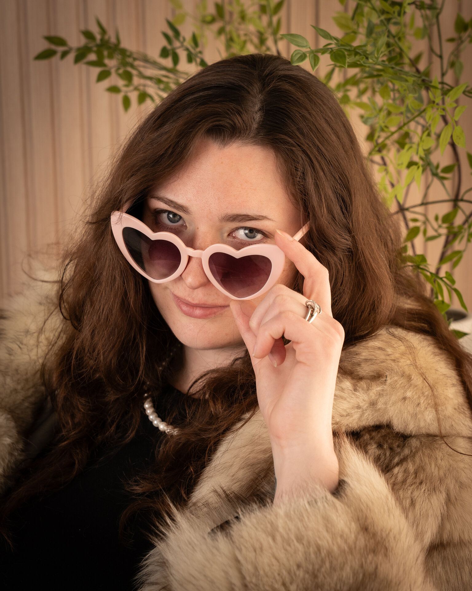 Woman peering over heart-shaped sunglasses, Saskatoon portrait