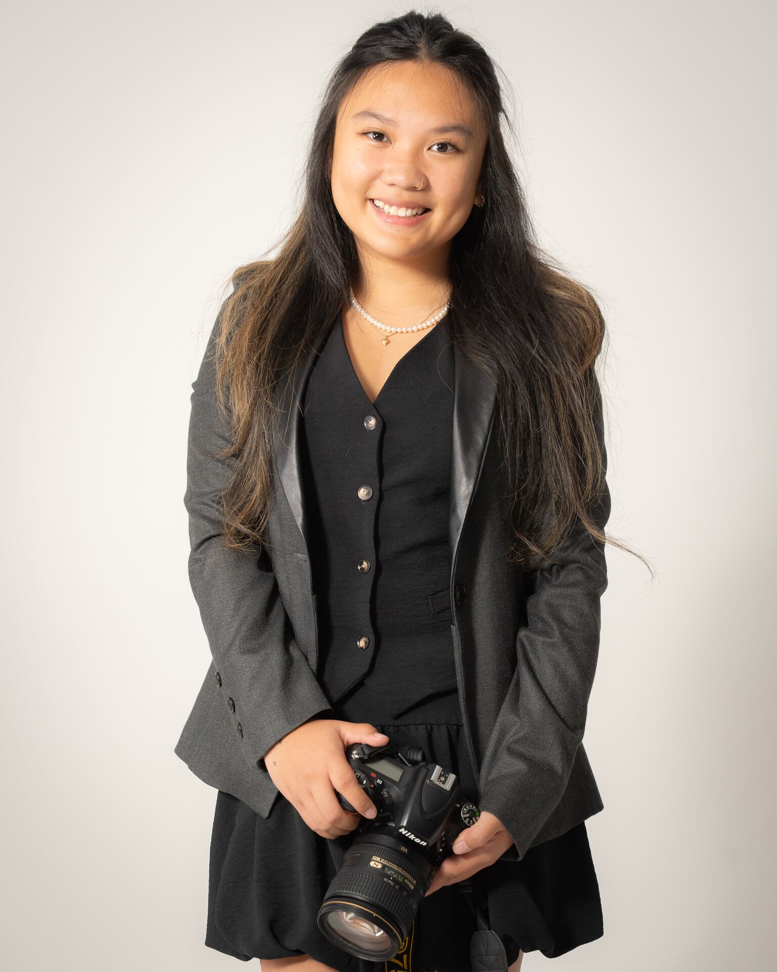 Woman smiling while holding a camera, Saskatoon portrait
